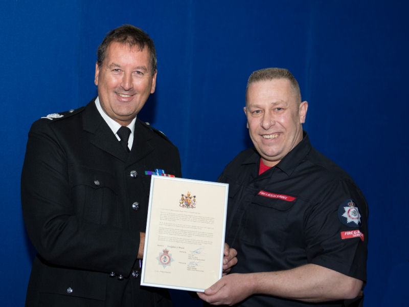 Fire-fighter Stephen Brown being awarded the Queen’s Fire Brigades Long Service and Good Conduct Medal from Area Manager (AM) John Simons. Fire-fighter Stephen Brown being awarded the Queen’s Fire Brigades Long Service and Good Conduct Medal from Area Manager (AM) John Simons.