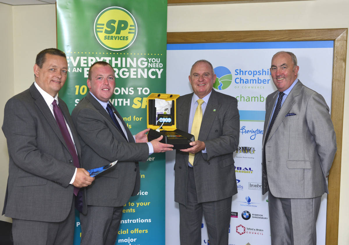 Nick Hassell and Paul Watts (left) hand over the defibrillator to Richard Sheehan and chamber president Peter Guy (right) at Trevithick House on Stafford Park in Telford.