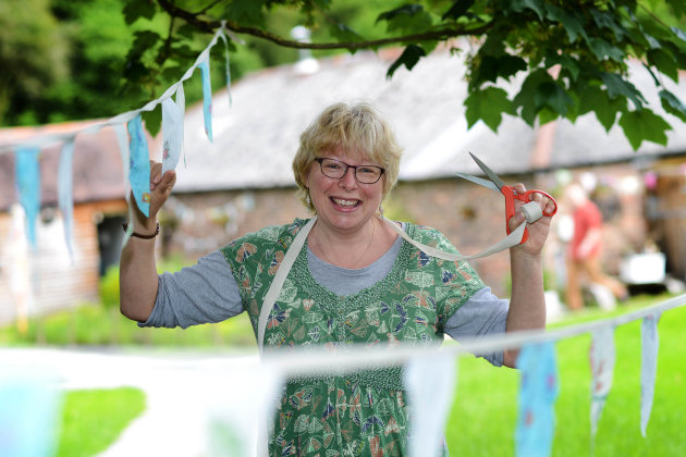 Joanne Clarke, volunteer crafter at Branching Out at Wyldwoods, hangs bunting in preparation for the wedding fayre
