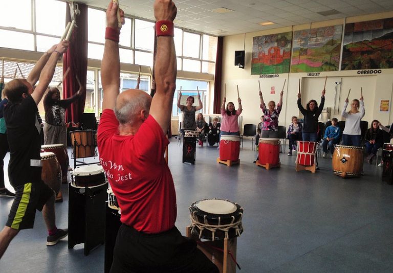Parents and children try out Taiko drums at summer school