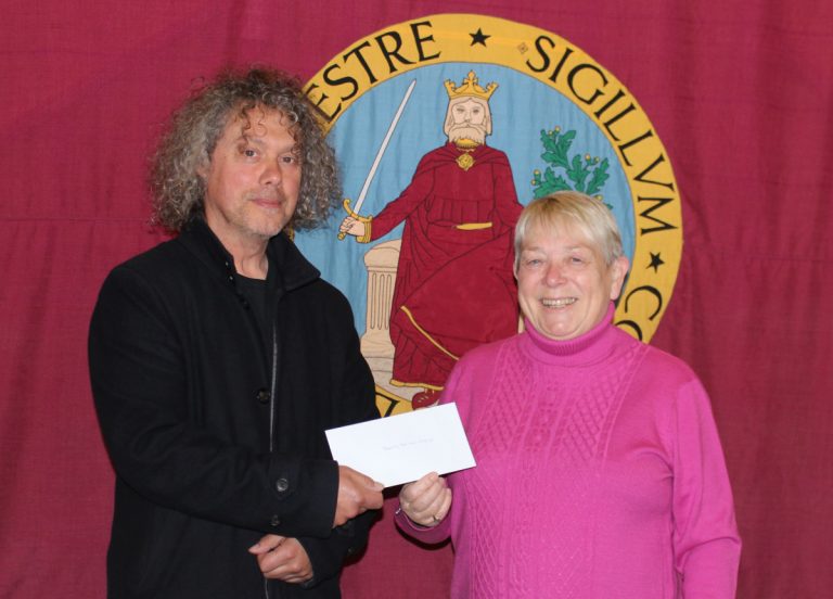 Oswestry Town Mayor, Sandy Best, presents a cheque on behalf of Oswestry Town Council to Neil Phillips of Oswestry Heritage Gateway towards the funding of a WW1 beacon lighting on Old Oswestry hillfort