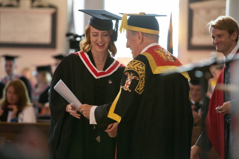 Dr Gyles Brandreth presents a UCS student with their degree certificate at a previous graduation ceremony