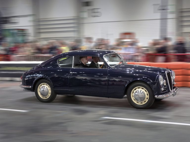 Harry Ruffell-Hazell driving the 1955 Lancia Aurelia he restored at the London Classic Car Show