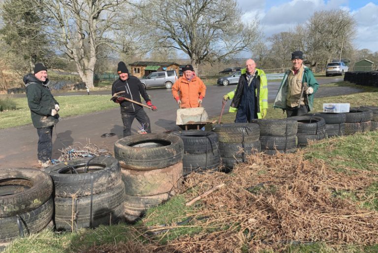 All smiles, Martyn Silcox (centre) with fellow volunteers working on the tyre wall at Triangle Bend, Loton Park Hill Climb