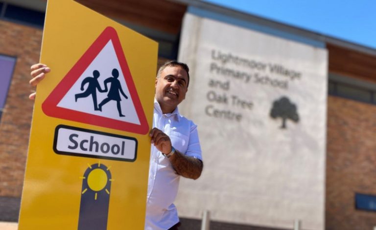Councillor Raj Mehta with one of the new enhanced school safety zone signs. Photo: Telford & Wrekin Council