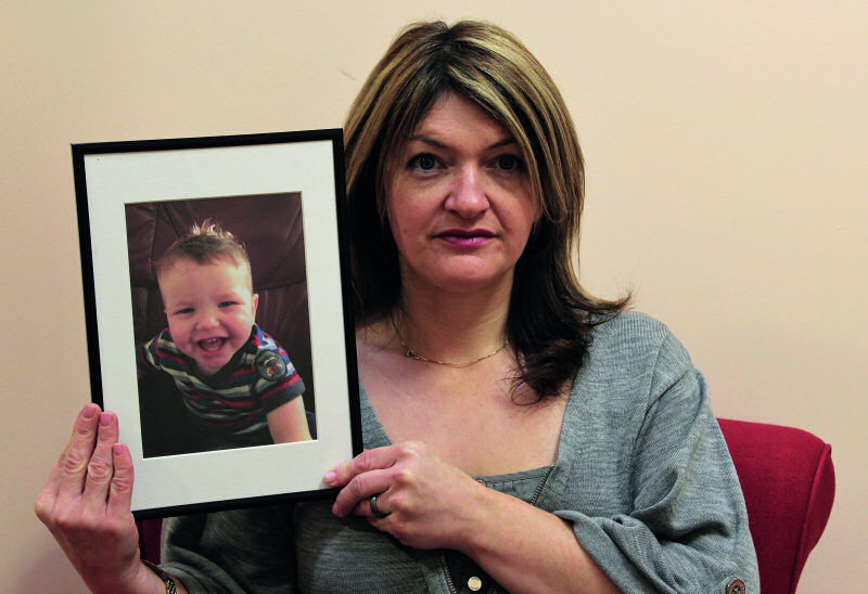 Alison Mullis holding a picture of her son Arthur
