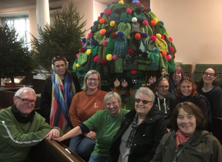 Members of the Castlefields Yarn Bombing Crew with their decorated Christmas tree at St Chad’s