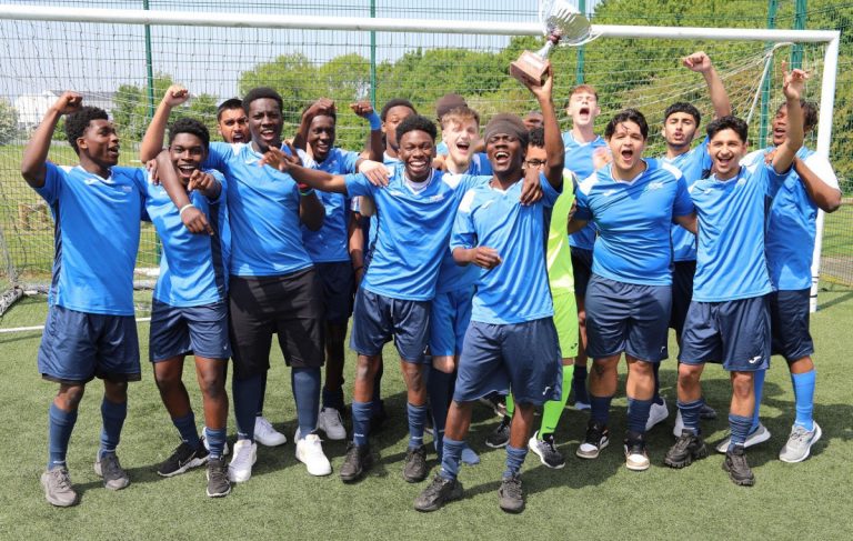 Telford College men’s football team celebrates with the trophy after an undefeated season