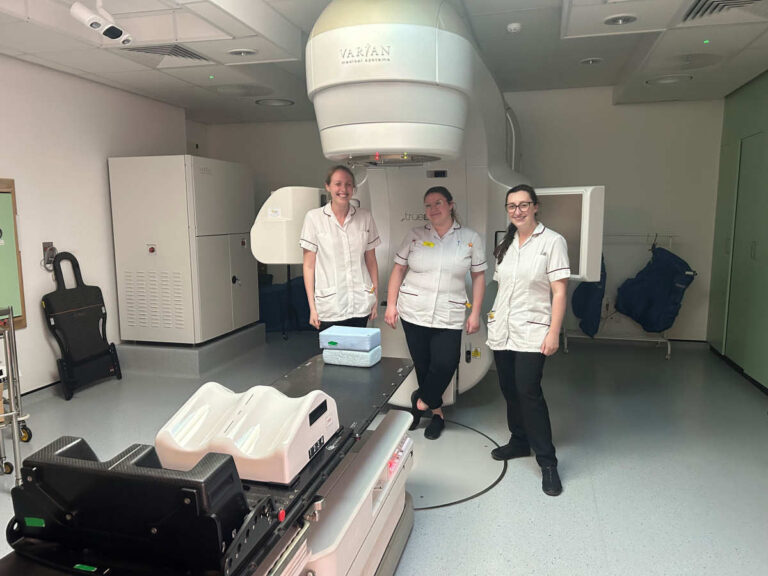 Nicola Wolstenholme, Ugne Valuntukeviciute and Francesca Eden in front of an existing LINAC