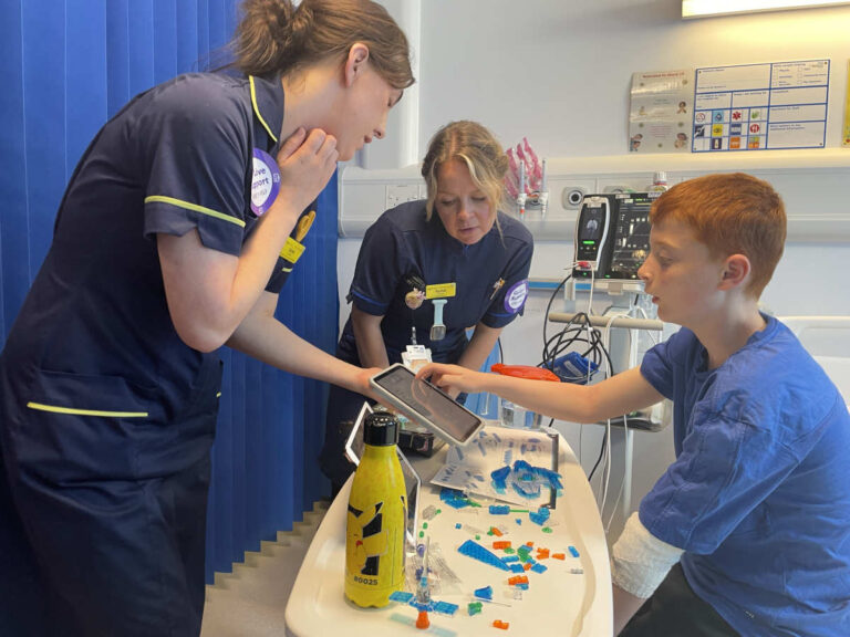 Esme Griffiths, left, and Rachel Bennett, right, with a patient showing them the new digital system