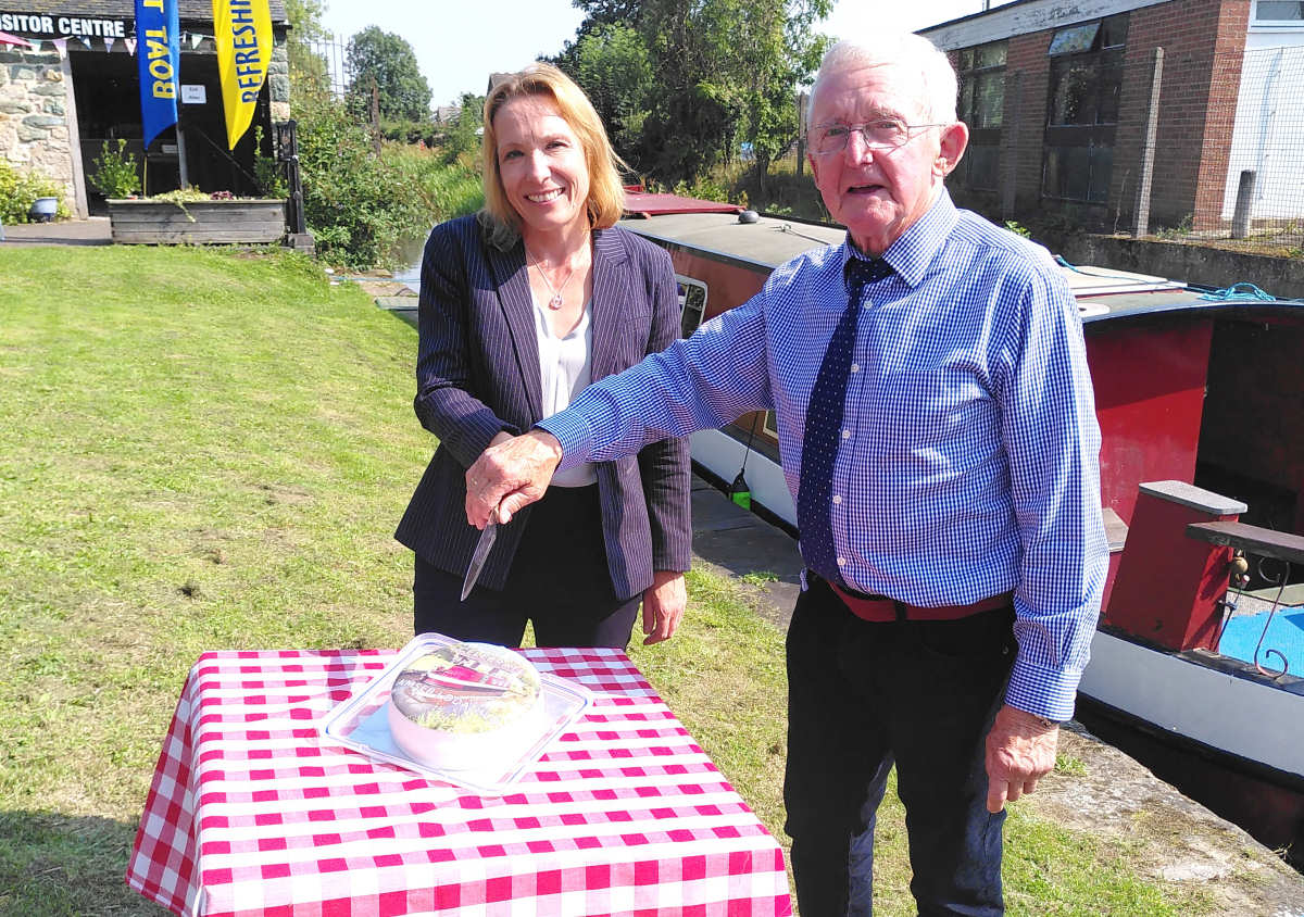 Helen Morgan MP cuts the celebration cake with Graham Deakin