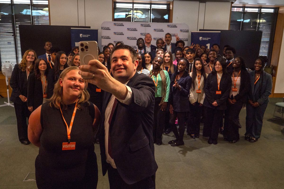 Shaun Davies MP taking a picture with Libby Hewlett and other students from the programme