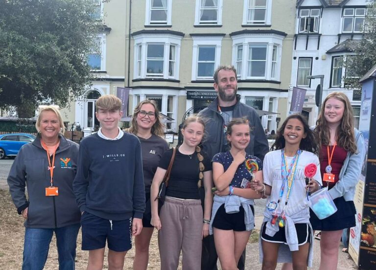 Kerry Williams, of SYA, Alison Gill, of Aico, and Lee Overton, of SYA, with some of the young people on their trip to Llandudno